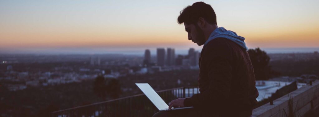 image of a guy at the laptop on a rooftop