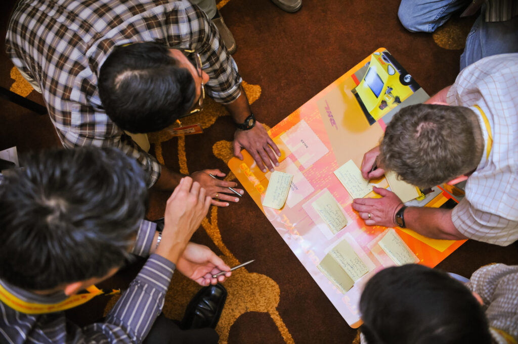 Picture of birds-eye view of people writing on post it notes