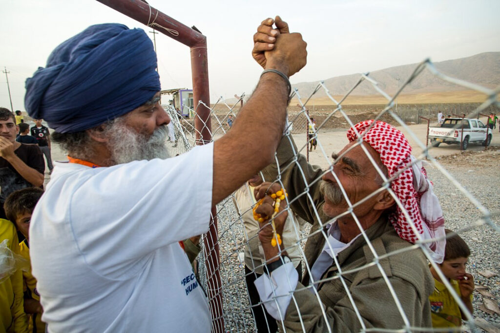 Ravinder Singh and refugee at camp. Sihk principles
