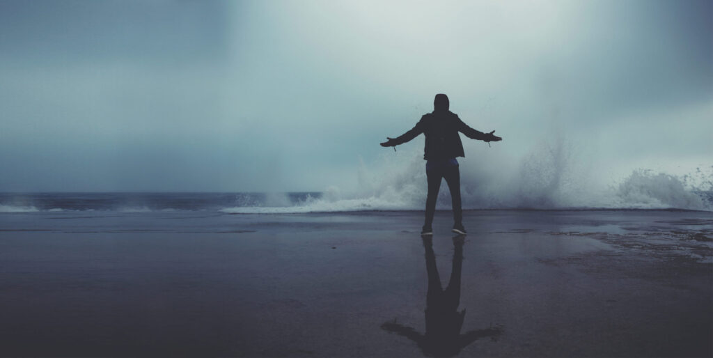 image of a person in front of a stormy sea