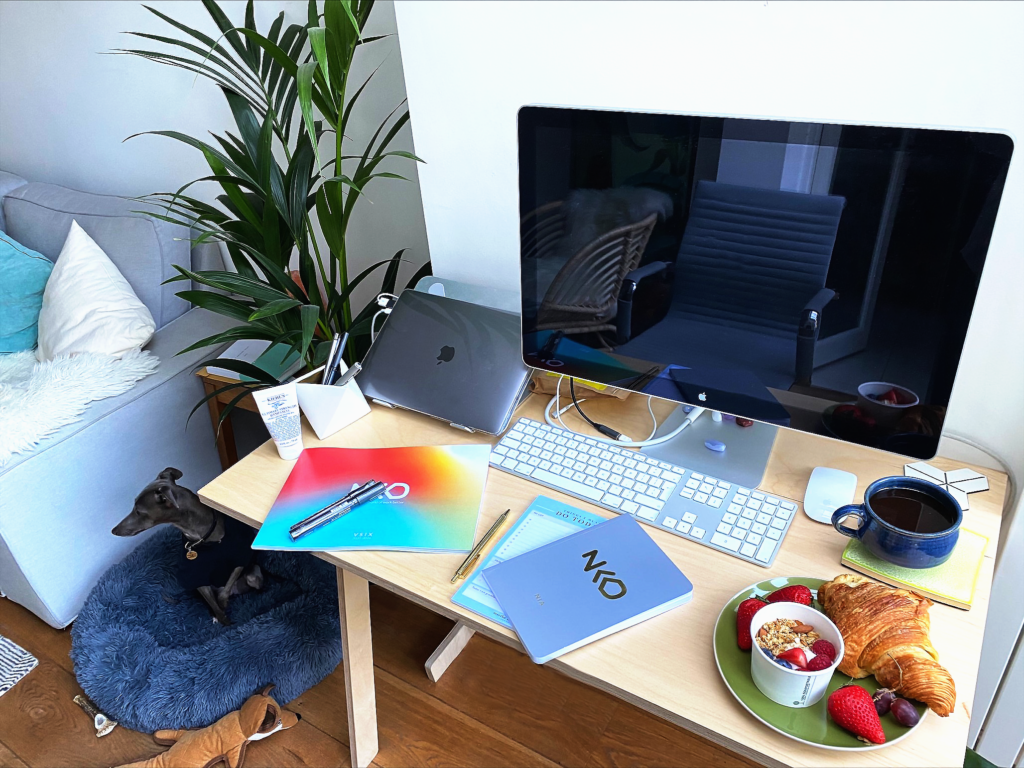 a picture of a NKD employee'desk with NKD books, NKD Strategy and breakfast