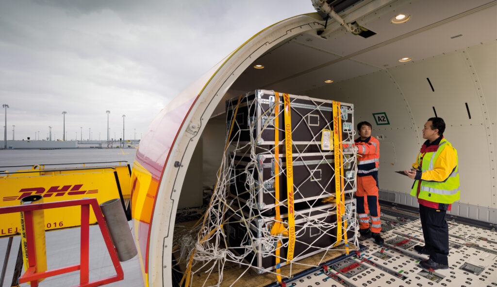 man counting up cargo in DHL Express plane