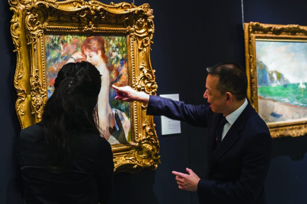 A man working in an art gallery with a customer
