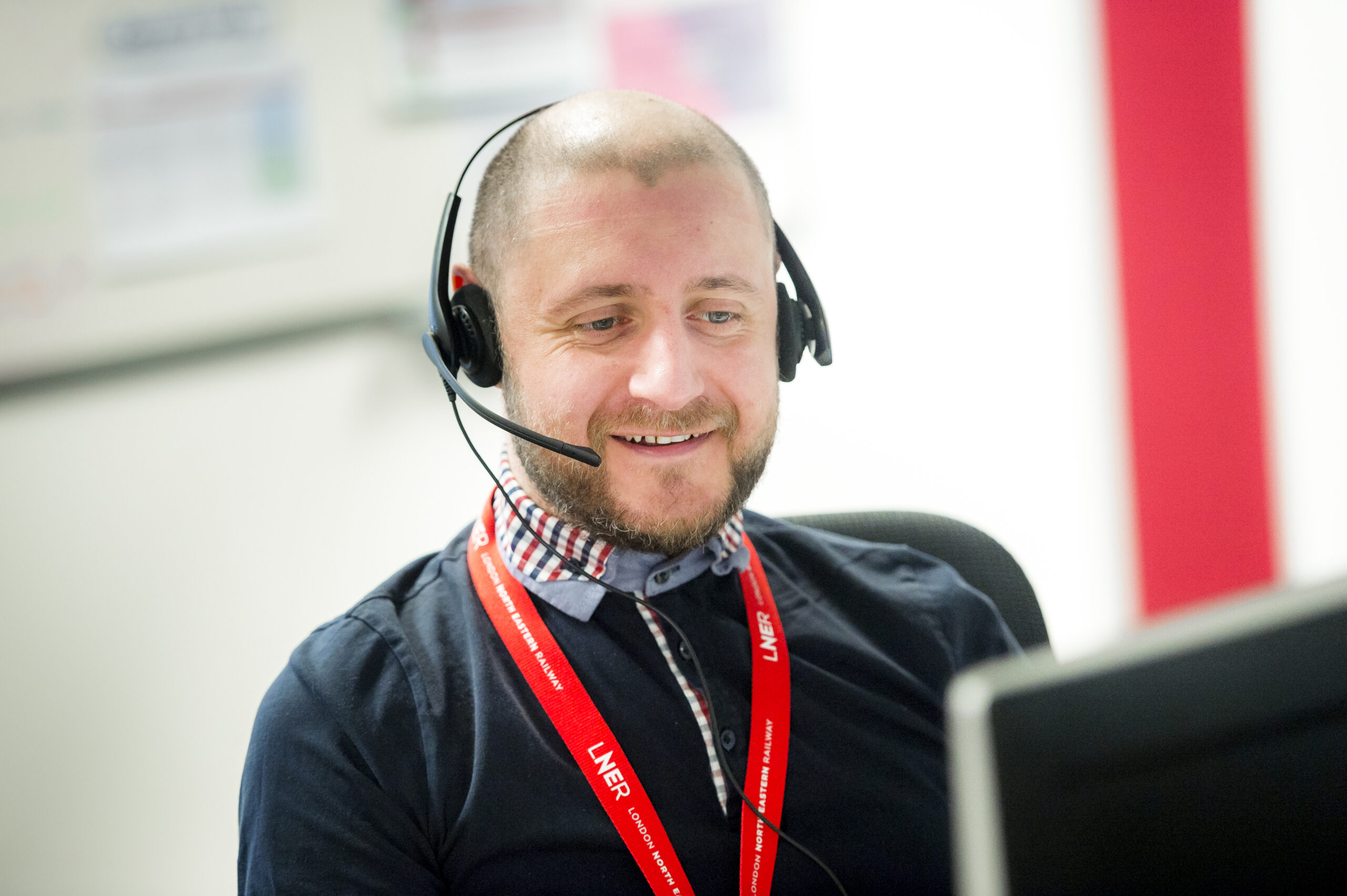 LNER Contact centre customer manager working on the phone wearing a headset